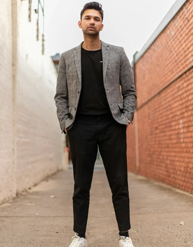 Exemple de tenue : blazer gris à carreaux, haut et pantalon noirs, baskets blanches